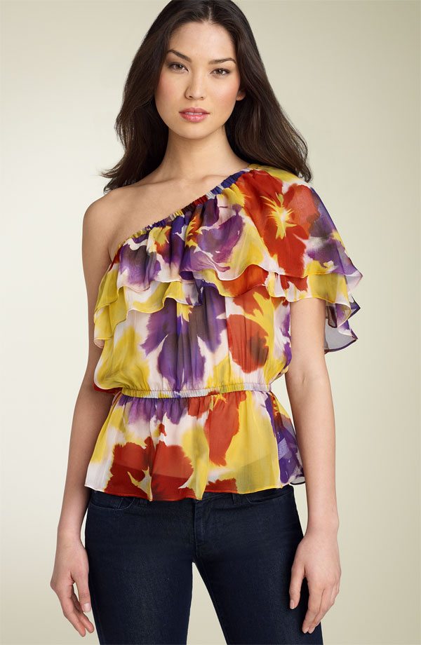 Blusa de corte asimétrico con vuelos que enfatizan y dan volumen en el hombro.